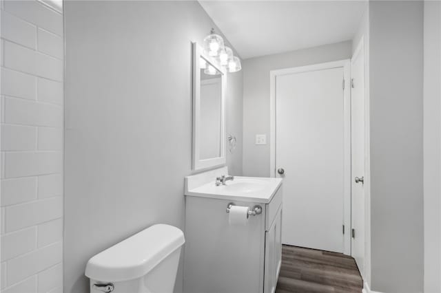 bathroom with vanity, hardwood / wood-style flooring, and toilet