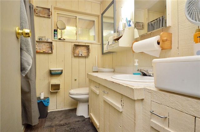 bathroom with wood walls, vanity, toilet, and hardwood / wood-style flooring