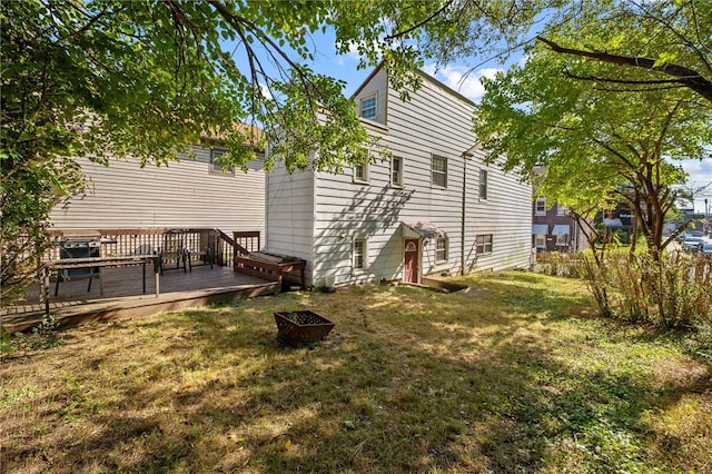 back of house featuring a wooden deck and a yard