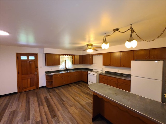 kitchen featuring ceiling fan, pendant lighting, sink, white appliances, and dark hardwood / wood-style floors