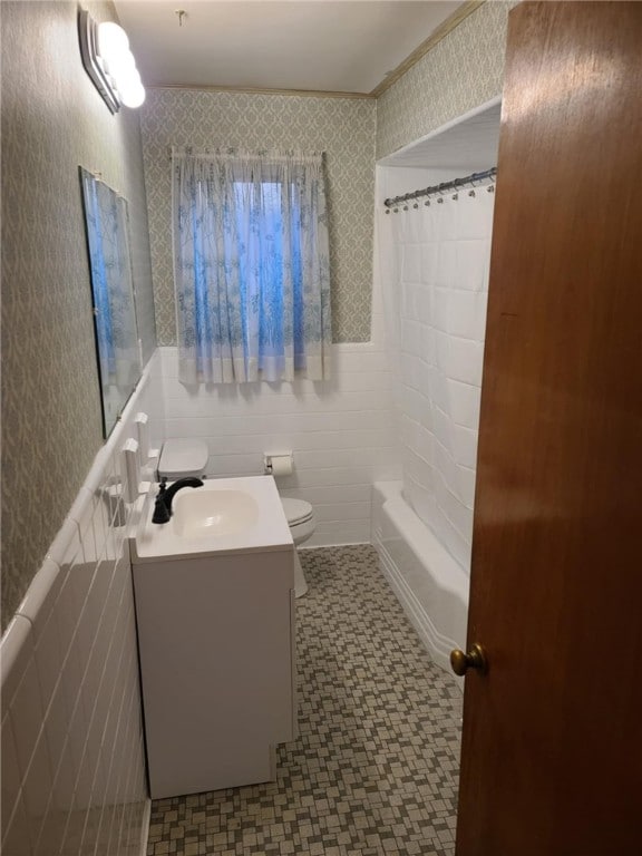 full bathroom with tile walls, vanity, toilet, and shower / bathtub combination with curtain