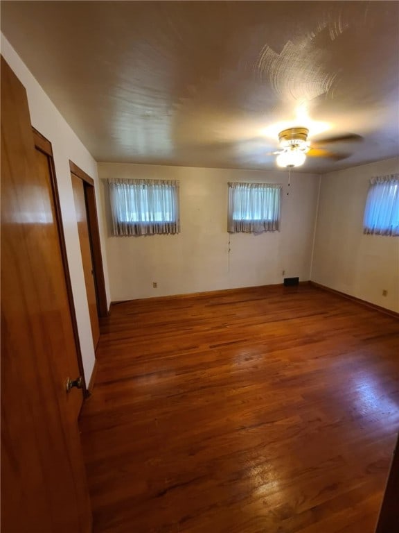 unfurnished room featuring ceiling fan and dark hardwood / wood-style flooring