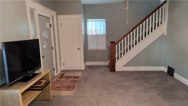 foyer featuring dark colored carpet