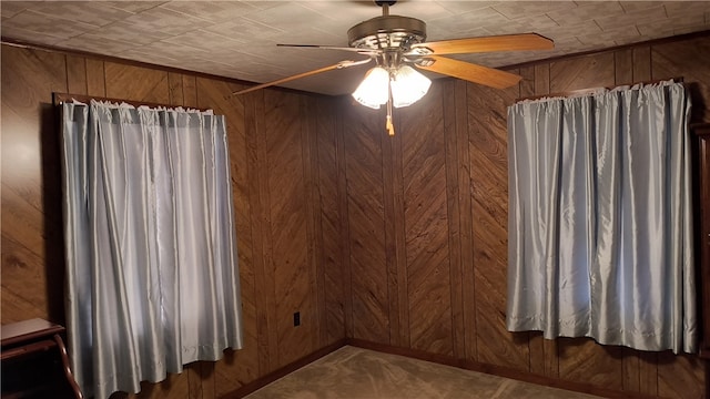 spare room with wood walls and ceiling fan