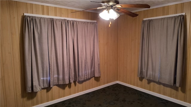 spare room with wooden walls, ceiling fan, and crown molding