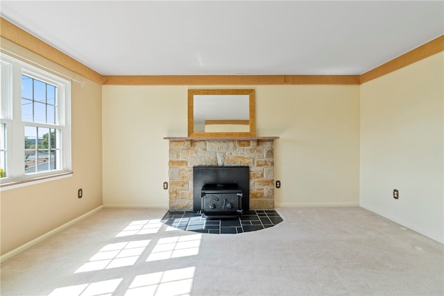 unfurnished living room featuring a wood stove and carpet floors