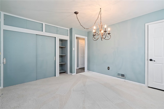 unfurnished bedroom featuring carpet, a chandelier, and a closet