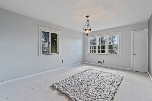 carpeted spare room featuring plenty of natural light