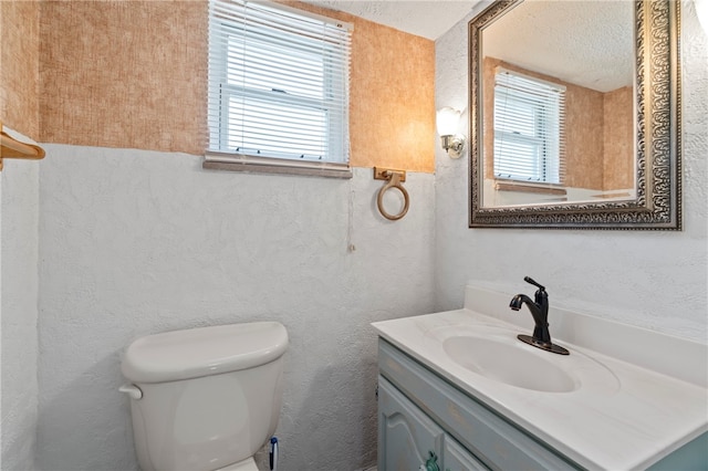 bathroom featuring a textured ceiling, vanity, and toilet