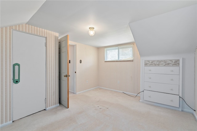 additional living space with light colored carpet and lofted ceiling