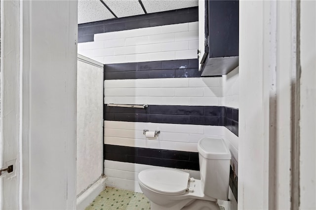 bathroom featuring a drop ceiling and toilet