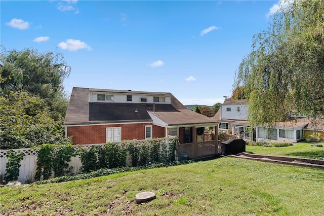 rear view of house featuring a yard