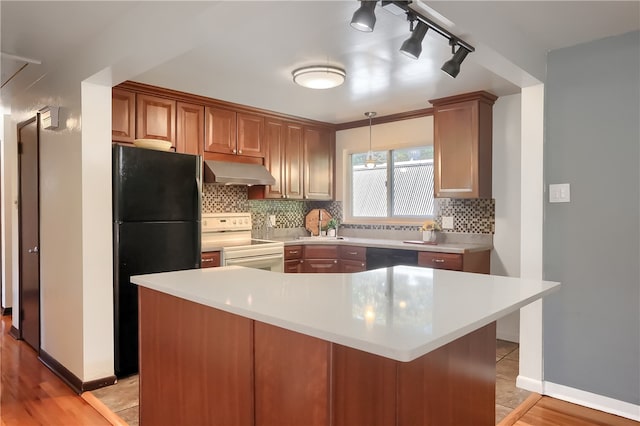 kitchen with black appliances, a kitchen island, exhaust hood, and light hardwood / wood-style flooring