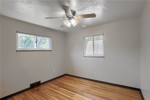 spare room with ceiling fan and light wood-type flooring