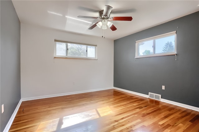 spare room with ceiling fan, light hardwood / wood-style floors, and a wealth of natural light