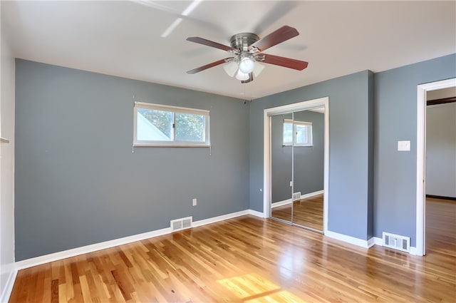 unfurnished bedroom with hardwood / wood-style floors, ceiling fan, and a closet