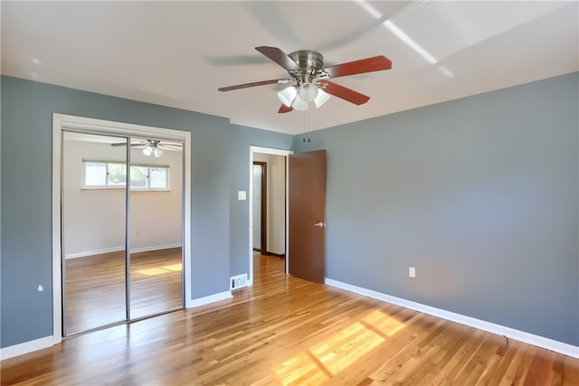 unfurnished bedroom featuring ceiling fan, a closet, and light hardwood / wood-style floors