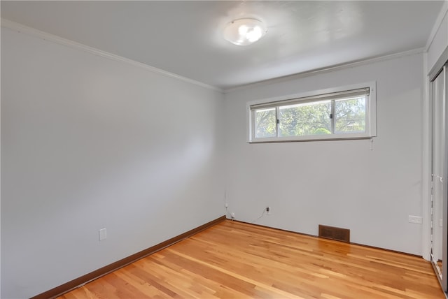 unfurnished room featuring hardwood / wood-style floors and crown molding