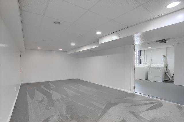 basement featuring a paneled ceiling, independent washer and dryer, and carpet floors