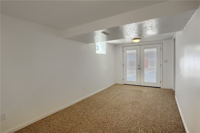 unfurnished room featuring french doors, carpet floors, and a textured ceiling