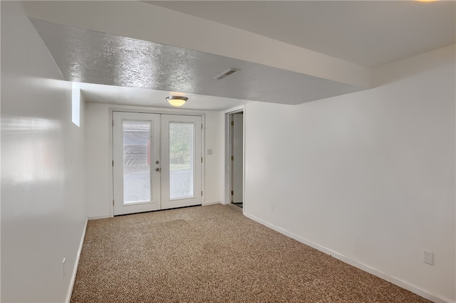 unfurnished room featuring french doors and carpet floors