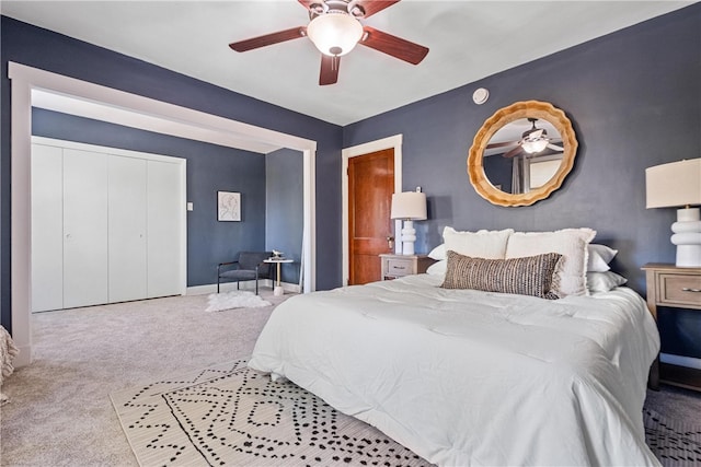 carpeted bedroom featuring ceiling fan and a closet