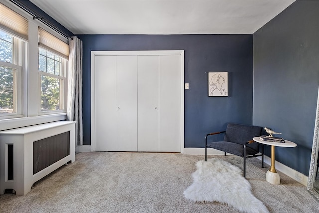 living area with light carpet and radiator