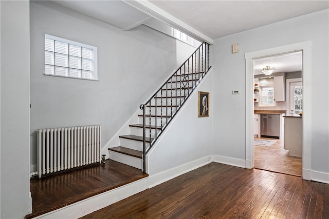 stairway featuring wood-type flooring and radiator heating unit