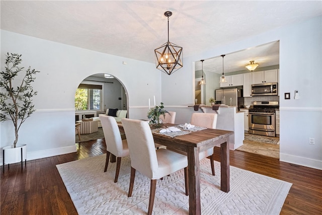 dining area featuring wood-type flooring and a notable chandelier