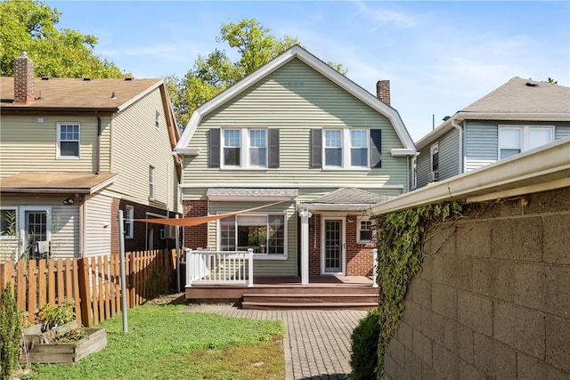 back of house featuring a wooden deck and a yard