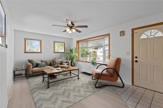 living room with light wood-type flooring, ceiling fan, and a wealth of natural light