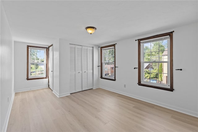 unfurnished bedroom featuring light hardwood / wood-style floors and multiple windows