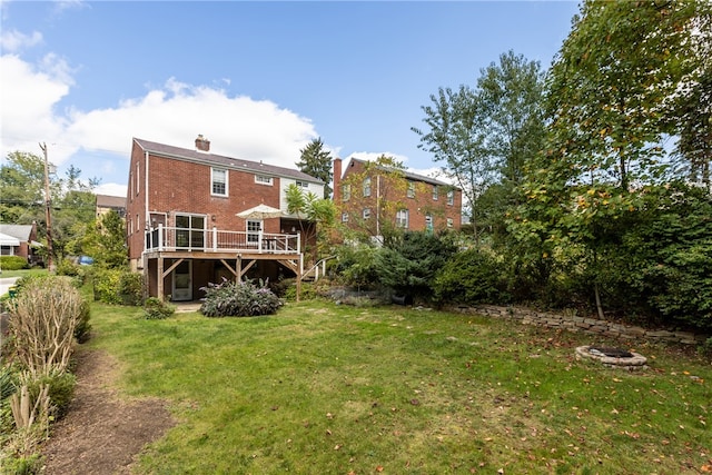 back of property featuring a lawn and a deck