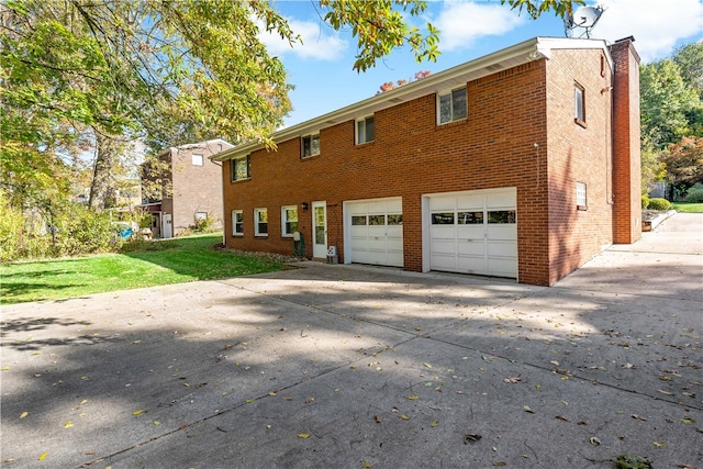 rear view of house featuring a garage and a lawn