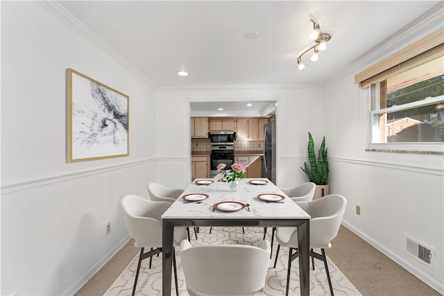 dining area featuring light carpet and crown molding