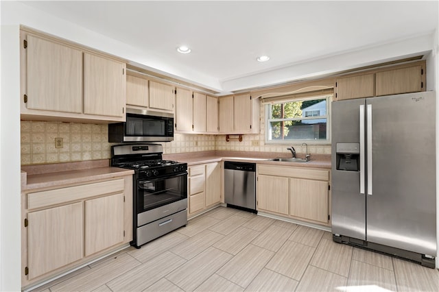 kitchen featuring light brown cabinetry, sink, stainless steel appliances, and tasteful backsplash