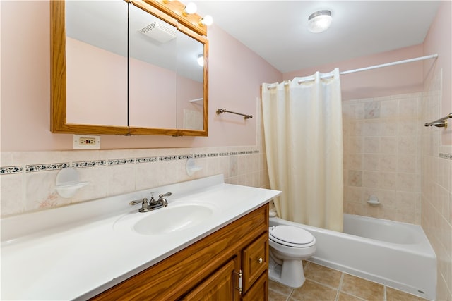 full bathroom featuring tile patterned floors, toilet, shower / tub combo with curtain, tile walls, and vanity