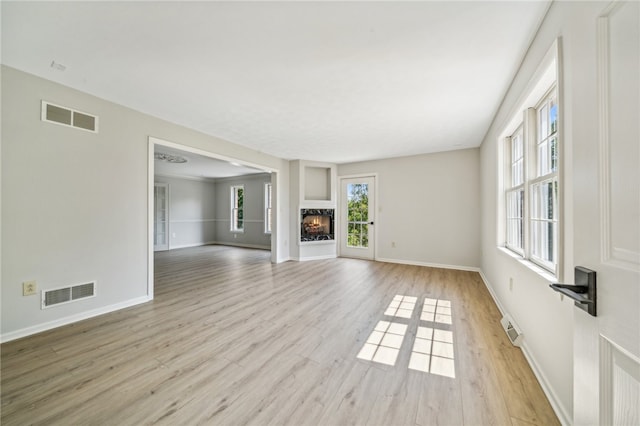 unfurnished living room featuring light hardwood / wood-style flooring and a wealth of natural light