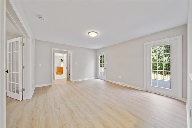 spare room with plenty of natural light and light wood-type flooring