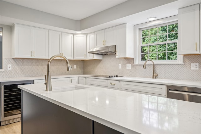 kitchen with decorative backsplash, white cabinetry, sink, and wine cooler