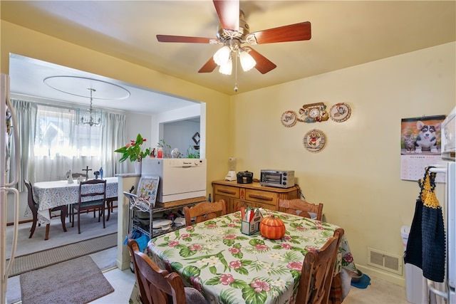 dining space featuring light colored carpet and ceiling fan with notable chandelier