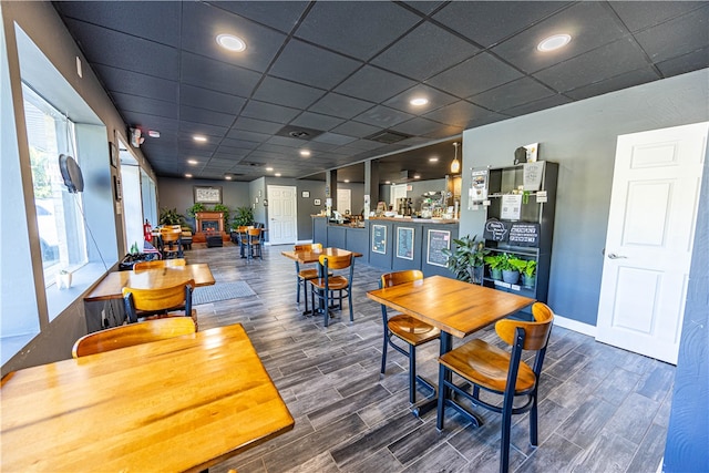 dining space featuring a drop ceiling and dark hardwood / wood-style flooring