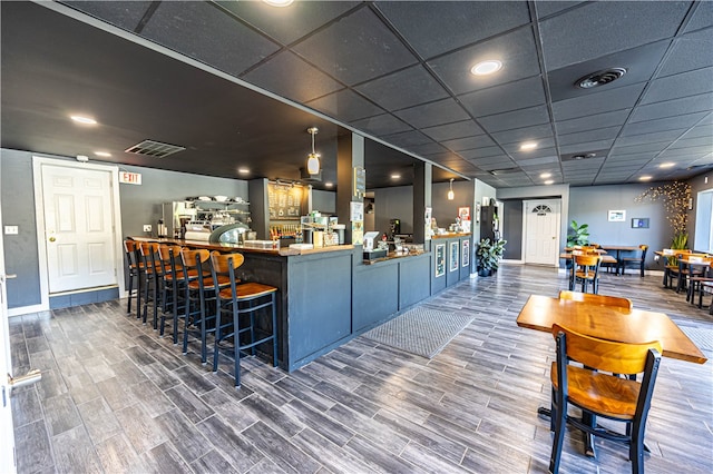 bar featuring a drop ceiling and hardwood / wood-style floors