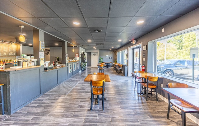 interior space featuring wood-type flooring and a drop ceiling