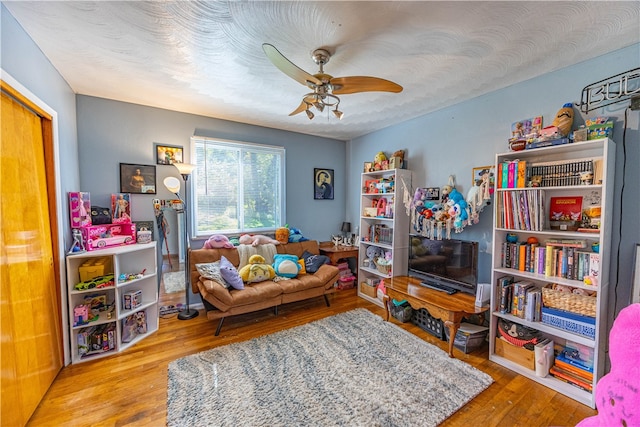 living room featuring hardwood / wood-style floors and ceiling fan