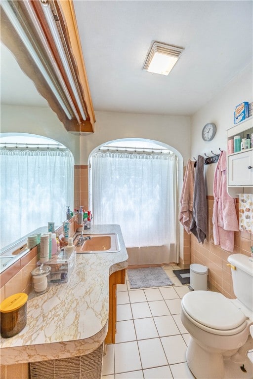 bathroom with a wealth of natural light, tile walls, and toilet