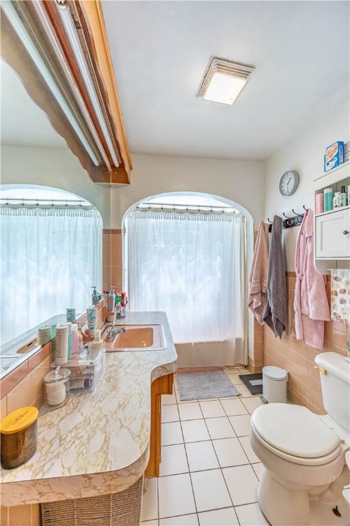 3740 Milligantown Rd, Upper Burrell, PA 15068 - bathroom featuring healthy amount of natural light, tile patterned flooring, vanity, and tile walls