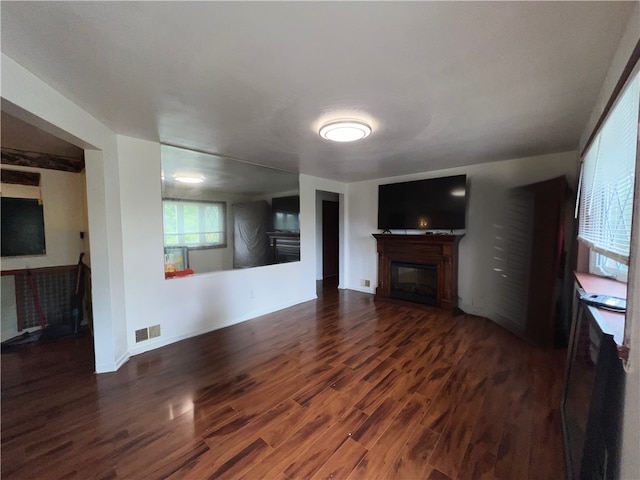 unfurnished living room with dark wood-type flooring