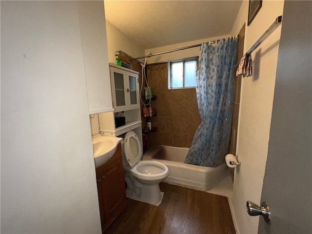 full bathroom with vanity, toilet, a textured ceiling, shower / bath combo with shower curtain, and hardwood / wood-style floors