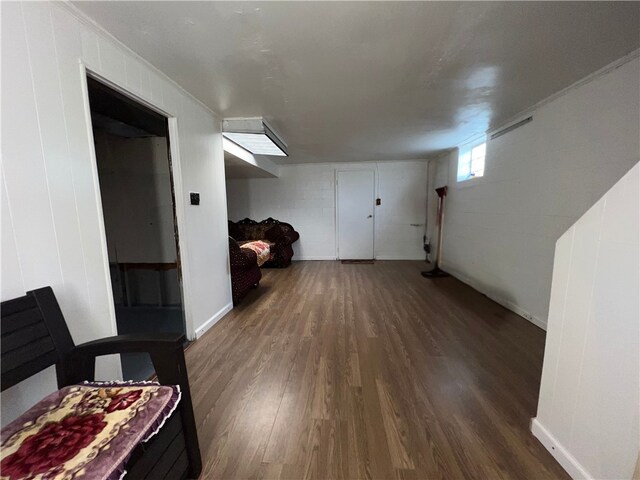 basement featuring ornamental molding and dark wood-type flooring